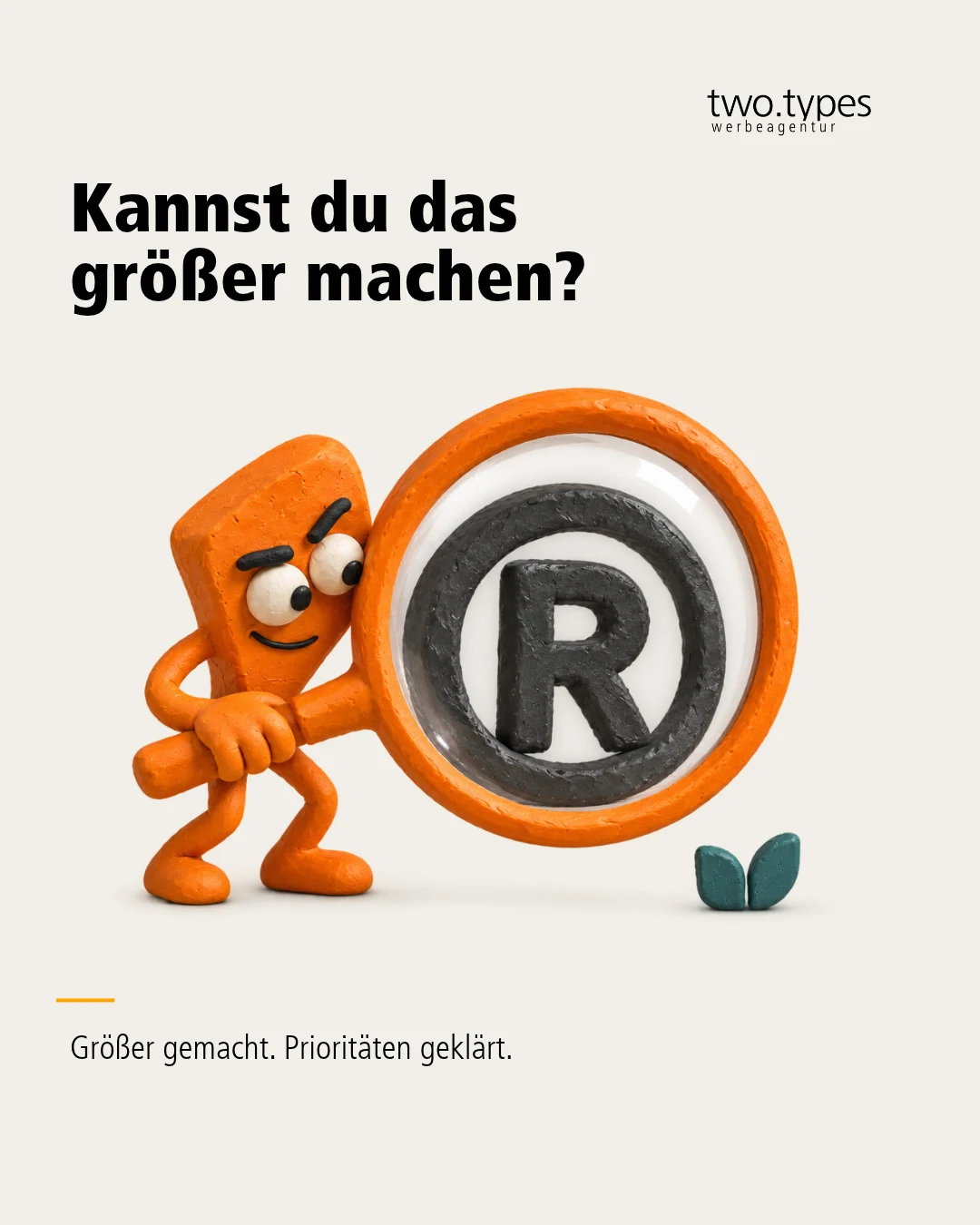 Eine kleine orange Knetfigur stemmt ein riesiges rundes Zeichen mit einem R in der Mitte.